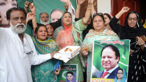 Supportrar i Multan, Pakistan. Nawaz Sharifs politiska supportrar firar Sharifs frigivning från fängelse. De sträcker upp armarna, håller i plakat med bilder på Sharif.