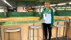 Nina Uusitalo är en av eftisets fyra coacher. En blond kvinna i vitgrön jacka står famför ett staket i trä.