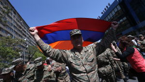 Soldaterna var endast beväpnade med armeniska flaggor då de tog till gatorna för att skydda protestmarscher från polisen i Jerevan. En soldat viftar med armeniska flaggan under en demonstration i Jerevan.