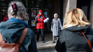 Carola Harmaakivi och Barbro Nedermo guidade västerbottniska deltagare i evenemanget. Två kvinnor talar till en grupp lyssnare.