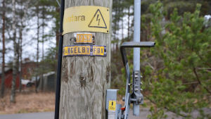 Bilderna är tagna i Hangelby i Sibbo på fredag. Det hade varit problem med elförsörjningen i området under morgonen. På en elstolpe står det "Livsfara" och "Hangelby fbk"