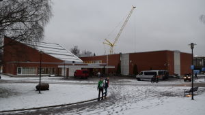 Laurentiushuset byggs strax bakom Anttilan koulu och Laurentiussalen. Anttilan koulu och Laurentiussalen i förgrunden. Byggarbetsplatsen i bakgrunden.