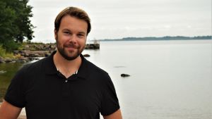 Tomi Ståhlberg, verkställande direktör för Suomen Saaristokuljetus, försöker själv komma ut till Mjölö så ofta som möjligt. Tomi Ståhlberg har en svart pikéskjorta på sig, har kort skägg och brunt hår. Han ser in i kameran och ser bestämt glad ut. I bakgrunden skymtar Helsingfors och skärgården, och vatten.