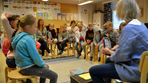 Tema är det nya favoritämnet, också bland ettorna. Alla barnen sitter i en ring i klassrummet. Läraren visar en bild.