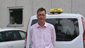 Den svenska servicen består, intygar Kim Kuhlberg. Han står vid en taxibil.