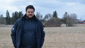 Jesse Mårtenson är huvudsakligen mjölkproducent Jesse Mårtenson på en åker med en stor sten i bakgrunden