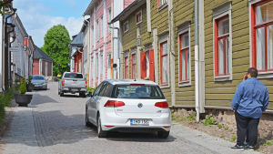 Kyrkogatan vimlar av både bilister och turister. En kullerstensgata med livlig trafik.