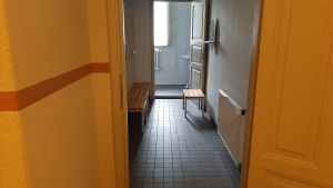 Heidekens nya källare mörk korridor med orange väggar och ljust tvättrum med fönster längre fram