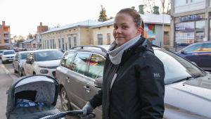 De gula husen skulle kunna renoveras, tycker Matilda Lill-Smeds. Hon önskar att det fanns fler klädaffärer på gatan. mamma med barnvagn