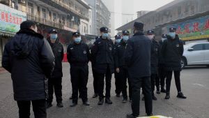 Människor ska ha smittats efter att de besökt en fisk- och skaldjursmarknad i den kinesiska staden Wuhan. Här står en grupp säkerhetsvakter utanför marknaden som haft stängt sedan första januari. Säkerhetsvakter står utanför den stängda fisk- och skaldjursmarknaden i den kinesiska staden Wuhan.