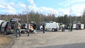 Rekoringens utdelning sker snabbt och är mer eller mindre över på en kvart. Bilar och människor på en parkeringsplats.