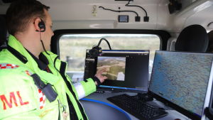 Nytt för i år är att räddningsverket får direktsänd bild från flygplanet. Metsäpalojen valvontalento, videokuvaa katsellaan pelastuslaitoksen autossa.