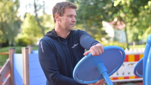 Det var helt avgörande att staden fick pengar av Folkhälsan och staten för att bygga motionsparken, enligt Joakim Mäkelä. Man håller i ett motionsredskap i en motionspark.
