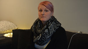 I dag mår Heidi Raitio bättre, men fortfarande har hon saker att bearbeta, Ung kvinna sitter i en soffa.