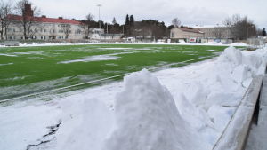 Det är trångt på Centrumplan i Ekenäs. Snöhögarna måste fraktas bort från planen om det ska spelas en match där. Centrumplan i Ekenäs den 5 mars 2018 kvart över två på eftermiddagen. Litet grön konstgräsplan, men ännu är det snö kvar.