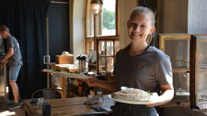 Fredrika Wulff säger att salladerna går bäst åt nu under sommaren. servitrisen fredrika håller i två färdiga pizzor