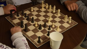 Det finsn många olika sätt att fördriva tiden på unkan i Tenala. Ett schackbräde och två barn som spelar. Man ser bara händerna på barnen.