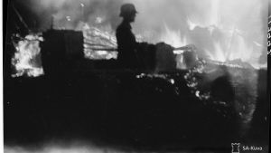 Krig sätter djupa spår. Soldat under fortsättningskriget. En soldat står vid ett brinnande förråd.