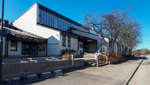 Normala eftermiddagar brukar området kring biblioteket och terminalen krylla av ungdomar som väntar på bussen. Ett vitt hus utifrån.