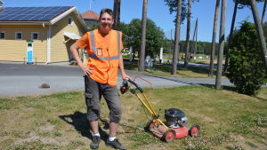 Axel Mattsson trivs med sitt arbete utomhus men poängterar att det är viktigt att dricka vatten, använda solkräm och keps. Axel Mattsson med en gräsklippare framför Pargas Golfbana.