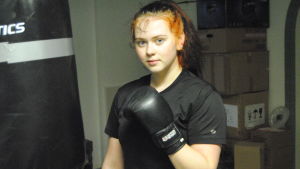Veera Karlsson tränar boxning i farfars garage. Veera Karlsson står bredvid en boxningssäck.