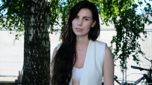 Skott har studerat låtskrivande på djupet och kan det här med att framkalla känslor. Den svenska artisten Skott poserar bakom scenen på årets Flow-festival (2017), hon är klädd helt i vitt och har långt, mörkt hår.