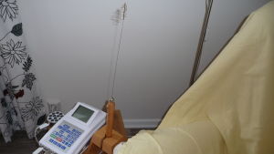 Apparaten och staven som används vid bioresonans. apparaten som mäter frekvenser. En låda med siffror och en stav med metallfjäder formad som spiral i toppen.