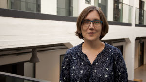 Blanka Henriksson forskar i kulturanalys på Åbo Akademi. Blanka Henriksson står i en universitetsmiljö. Hon bär en mörkblå blus eller klänning och har glasögon.