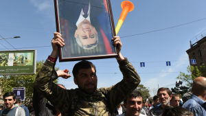 En demonstrant håller ett porträtt av premiärminister Serzj Sargsian upp och ner under en av de många demonstrationerna i huvudstaden Jerevan. Demonstrant håller ett porträtt av premiärminister Serzj Sargsian upp och ner under en av de många demonstrationerna i huvudstaden Jerevan.