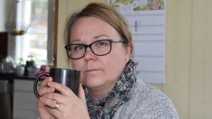 Christel Lindqvist-Jauhiainen har i flera repriser talat med tjänstemän, politiker och personal om bristerna i kommunens eftermiddagsverksamhet. Christel Lindqvist-Jauhiainen sitter i sitt kök med kaffemugg i handen. Allvarlig, ler inte.