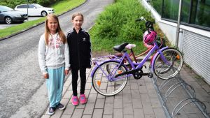 Sofia Sormunen och Tinja Saarinen tycker att det finns bra cykelvägar i Lojo, förutom på några ställen där det finns guppar i vägen. Två barn vid sina cyklar utanför Prisma i Lojo.