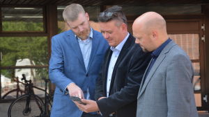 Från vänster: Jakob Wikström, Bernt Klockars och Thomas Sundell. Tre män står och ser på en telefonskärm.