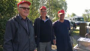 Henrik Jensén, Ralf Storberg och Vidar Ginlund uppskattar naturen i skärgården. Tre män med röda skärmmössor står vid en korvgrill.