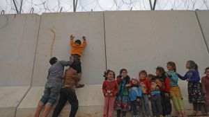 Syriska flyktingbarn klättrar vid en gränsmur som Turkiet byggt mot den syriska byn Kafr Lusin, i Idlib. Syriska flyktingbarn klättrar vid en gränsmur som Turkiet byggt mot den syriska byn Kafr Lusin, i Idlib.