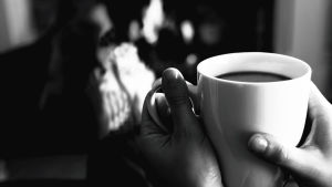 Sandra fick vara på sin vakt så att maken inte fick fler utbrott. Händer som håller i en kaffemugg.