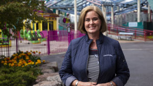 Borgbacken kommer fortfarande begränsa antalet besökare, säger verkställande direktör Pia Adlivankin. Porträtt av en kvinna i axellång polkafrisyr. Hon tittar in i kameran och ler. I bakgrunden syns nöjesfältet Borgbacken.