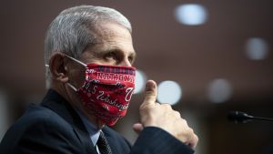 Anthony Fauci tror att vardagen kan återgå till det normala tidigaste i slutet av nästa vår - om tillräckligt många amerikaner vaccinerar sig. Anthony Fauci iklädd ett rött ansiktssydd ger tummen upp.