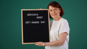 Martina Harms-Aalto är journalist och språknörd. Hon gör intervjuer som hörs i podden och i Yle Vega på lördagar. Martina Harms-Aalto håller i en svart skylt med vit anagrammen: "Näst sista ordet, sätt roande sist".