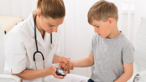 Diabetes är en av våra folksjukdomar som ökar snabbast just nu. Ung kille får sitt blodsocker mätt av kvinnlig hälsovårdare.