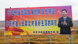 Ulkolinja: Kuka on Xi Jinping? Iso juliste keskellä autiota näkymää. Julisteessa kiinankielistä tekstiä ja Xi Jinping.