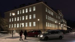 En tid bodde personalen på översta våningen på sjukhuset. Stort gult flervåningshus en vinterkväll. Gatulykta utanför.