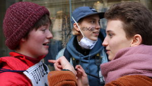 Flo Behets (t.v.) från Mechelen deltar i demonstrationen tillsammans med sina vänner. Flo Behets (t.v.) demonstrerar i Leuven tillsammans med över 10 000 andra.