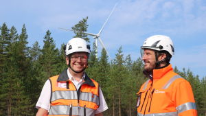 Jakob Kjellman och Michael Sandberg. Två män med skyddsvästar och -hjälmar. I bakgrunden skymtar ett vindkraftverk.