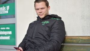 Lagkapten Zacharias Ekström håller kontakt med lagkamraterna per telefon. Zacharias Ekström sitter med telefonen i handen.