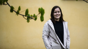 Professorn i EU-rätt Päivi Leino-Sandberg anser att EU fortsätter en utveckling där man tänjer på EU:s grundfördrag. Professorn i EU-rätt Päivi Leino-Sandberg står framför en gul vägg och ler mot kameran. I förgrunden en trädkvist med gröna knoppar.