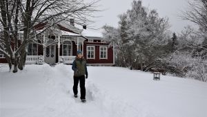 Lena päättää leikata Strömsön omenapuun keväällä ennen mahlannousua. Trädgårdsmästare Lena Gillberg kommer gående längs en stig i snön framför Strömsövillan