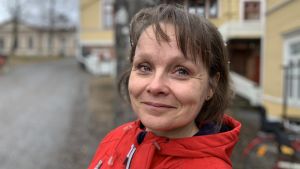 Helena Skog är föreståndare för Gustavsborgs daghem i Vasa. Kvinna i röd jacka står utomhus en regngrå dag, hon ler mot kameran.