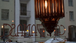 Inredning är precis som maten i syrisk stil. En lampa i Cafe Damascus med skyltfönstret i bakgrunden.