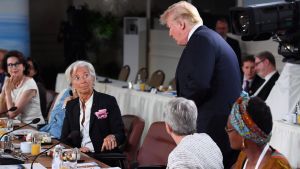 Trump anlände kraftigt försenad till lördagens frukostmöte kring jämställdheten. Christine Lagarde tittar upp på Donald Trump, 15 minuter försenad från jämställdhetsmöte
