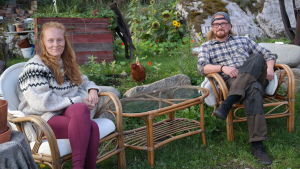 Ida Törnroos och Simon Strömsund har bott några år på Brännskär. Ida Törnroos och Simon Strömsund sitter tillsammans med en höna i sin trädgård på Brännskär